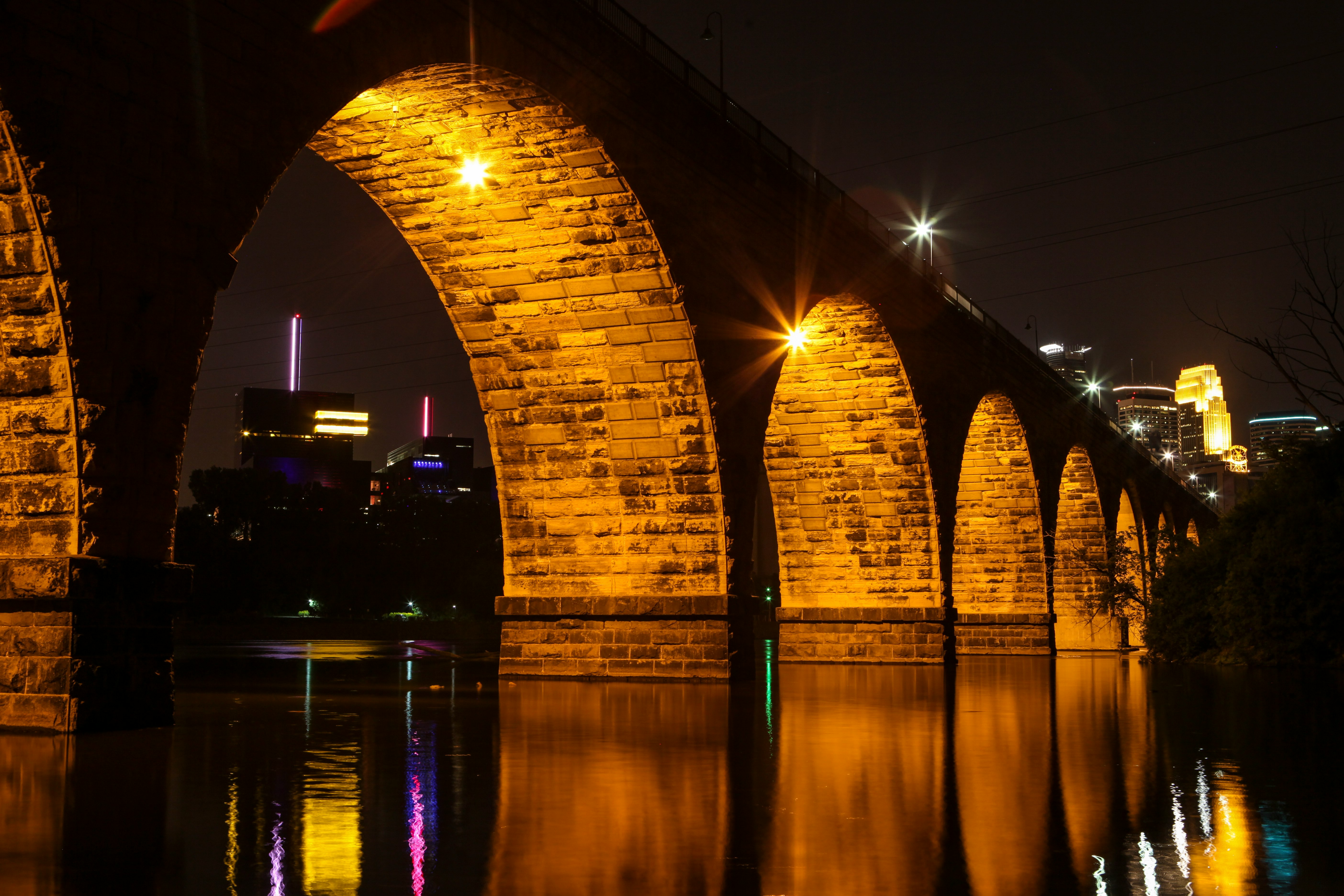 brown concrete bridge over water during night time